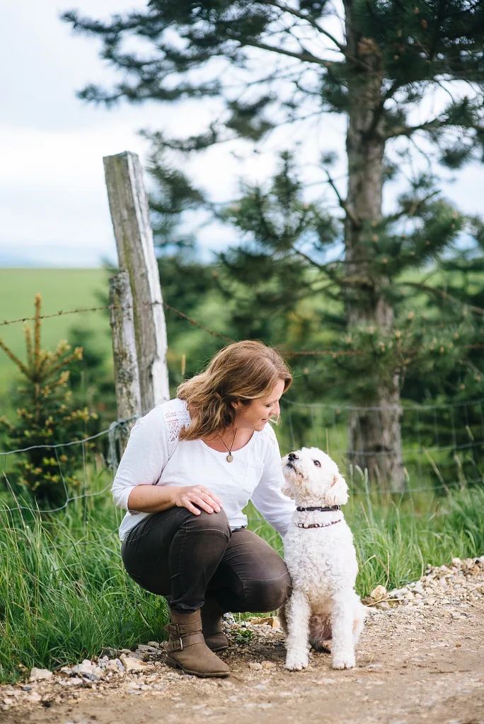 Kathrin Schneider und ein weißer Hund schauen sich an
